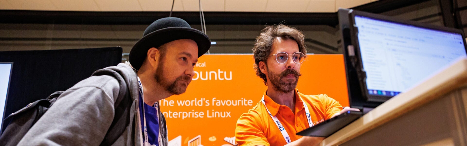Two men looking at a computer together.
